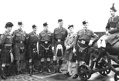 In picture of Pipe Majors Course: L/CPL George Johnston, Cameron Highlanders; CPL. Sandy Hain Black Watch; Cpl. T. Shearer, Argyll and Sutherland Highlanders; Cpl. Peter Forbes, Highland Light Infantry; P/M Bob Crabb, Scots Guards; Bobby Cuthberson; Cpl. G. Symon, Gordon Highlanders; and L/Sgt. Ramsay, Irish Guards